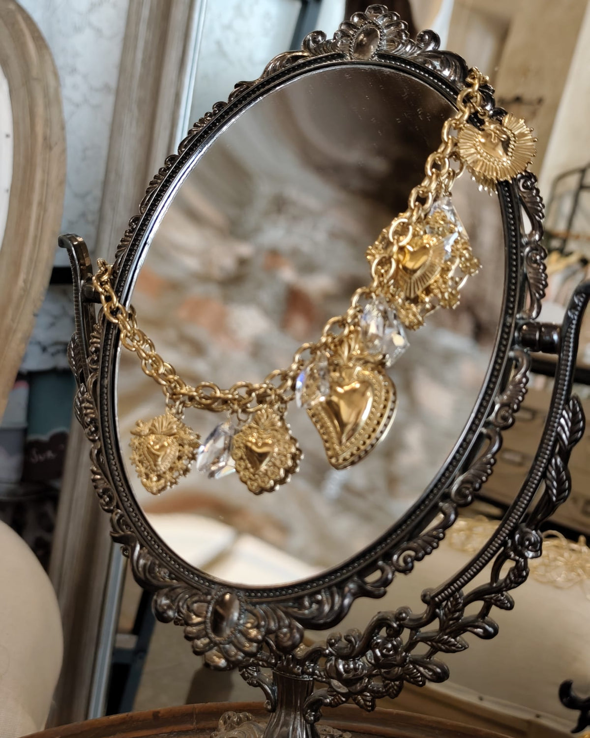 Collana charm dorata con cuori sacri e cristalli